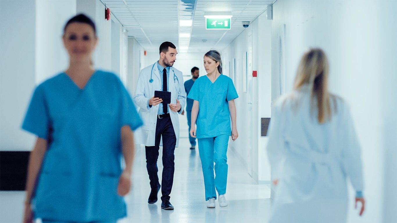 A group of healthcare workers walk down a hallway.