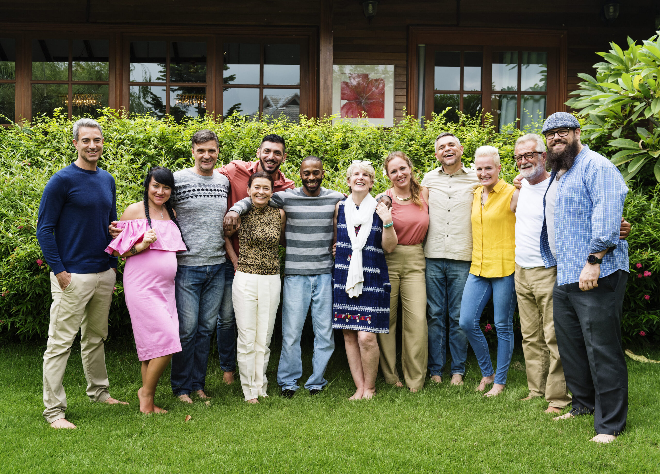 A group of people stand in a courtyard smiling at the camera.