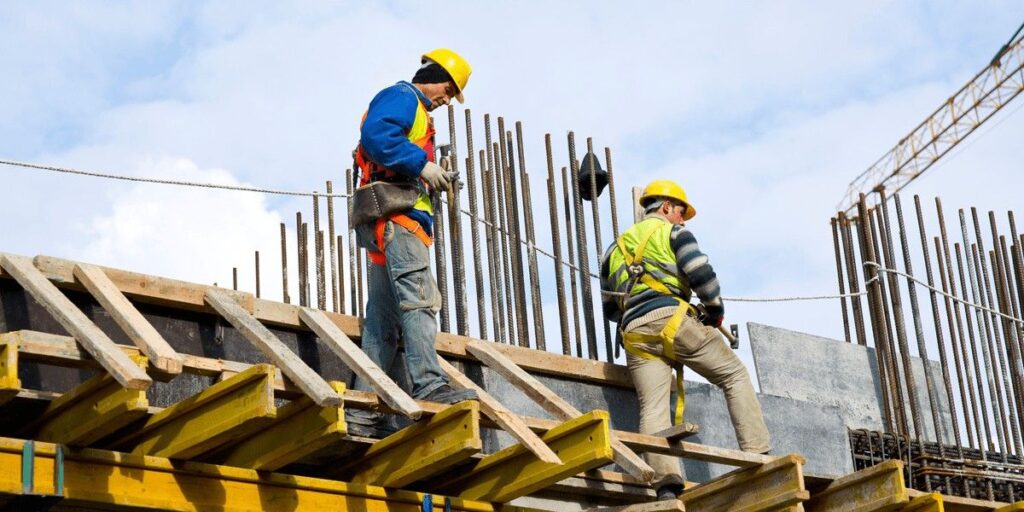 Two engineers in hard hats work on a construction project.