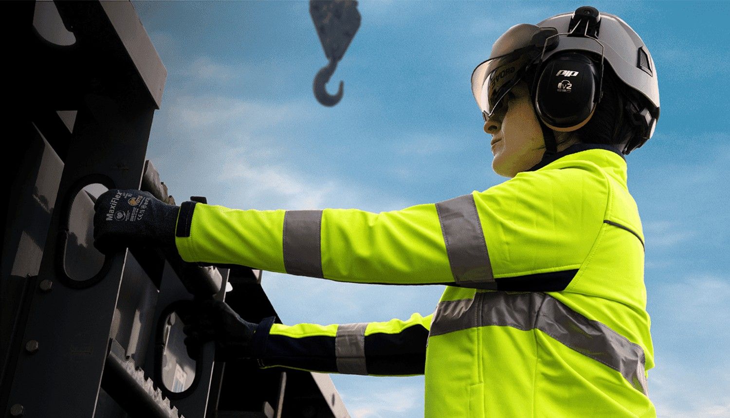 A woman in a high-vis jacket and hard hat works on a construction project.