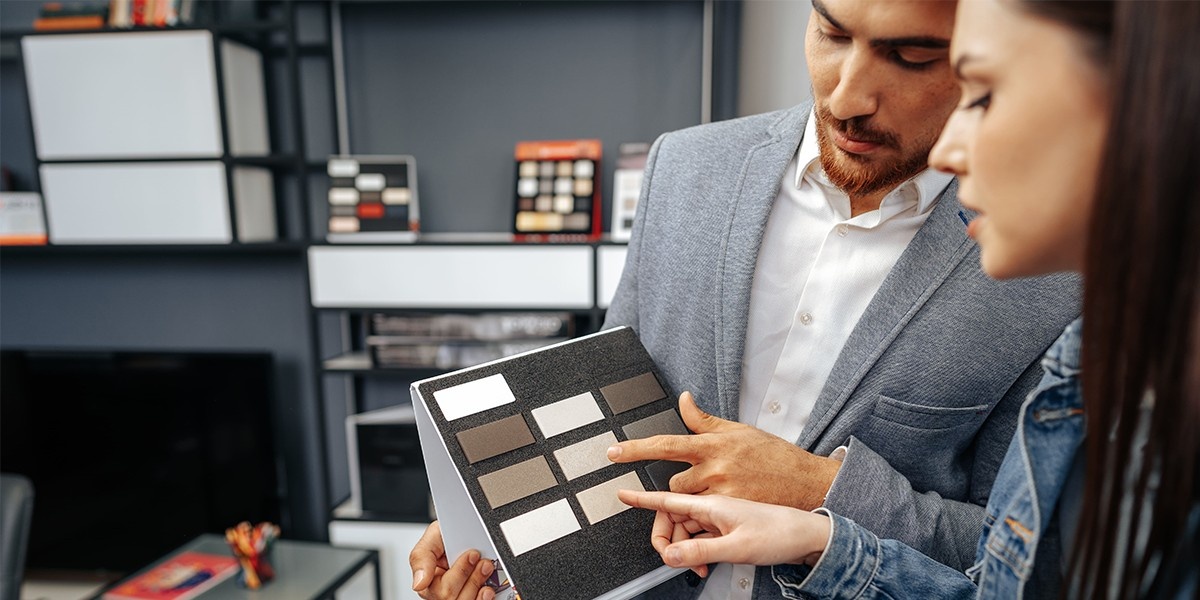 A man and a woman in business attire observe a set of data on a tablet.