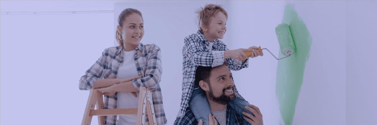 Father & kid smiling while doing paint on wall