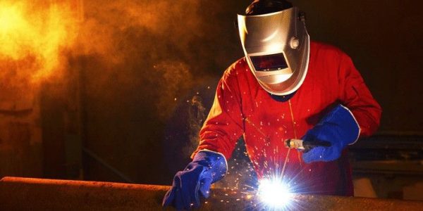 Welder working a welding metal with protective mask and sparks