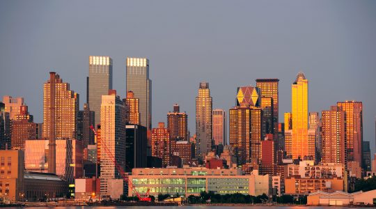 New York City Manhattan sunset panorama with historical skyscrapers over Hudson River with beautiful red color sunshine reflection viewed from New Jersey Weehawken waterfront.