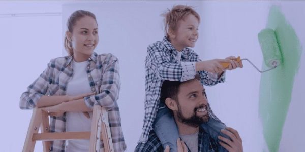 Father & kid smiling while doing paint on wall