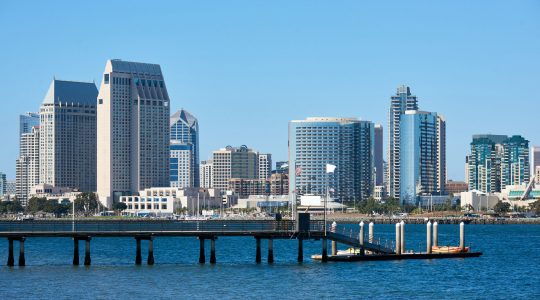 Pier with kayak boats, downtown skyline on background. San Diego, California