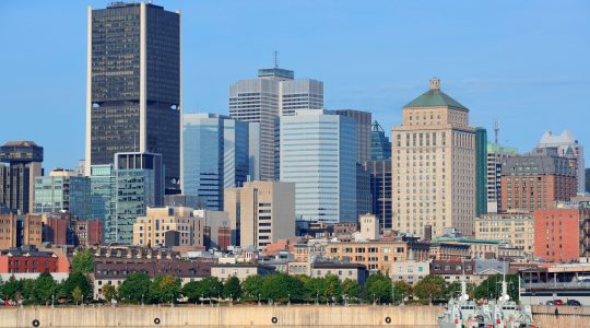 Montreal city skyline over river in the day with urban buildings